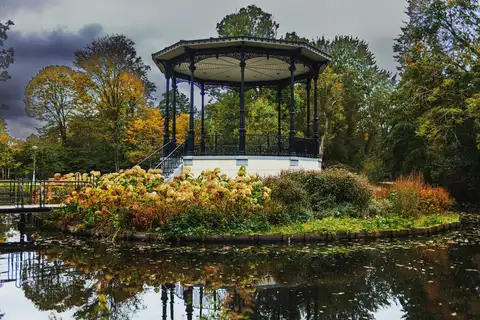 Quiosco de música del Vondelpark de Ámsterdam reflejado en el estanque, rodeado de hortensias y árboles amarillos en otoño