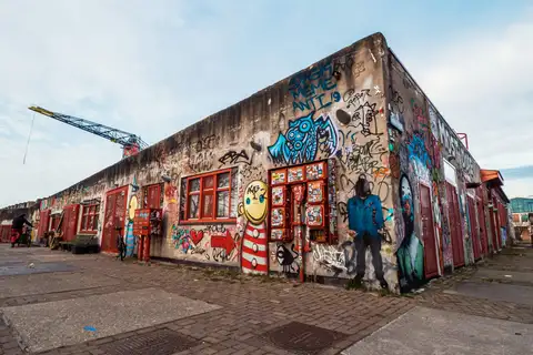 Nave del astillero NDSM en Ámsterdam Noord con las paredes cubiertas de grafitis y una grúa antigua al fondo