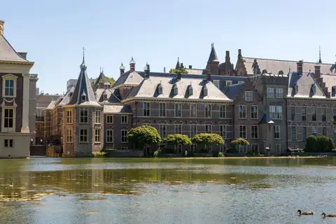 Edificios de ladrillo del Binnenhof con torreta y tejados de pizarra junto al estanque Hofvijver, con patos, en La Haya