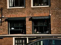 Fachada de ladrillo rojo de un coffeeshop con rótulo «coffee shop» en las ventanas, en un edificio histórico de Ámsterdam