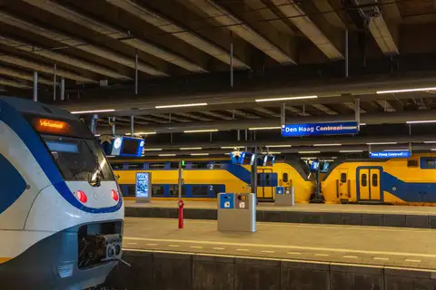 Andén de la estación de Den Haag Centraal con trenes amarillos y azules de NS bajo la cubierta de hormigón