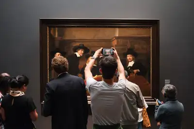 Visitantes de espaldas ante un cuadro de regentes del Siglo de Oro neerlandés en una sala del Rijksmuseum de Ámsterdam