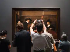 Visitantes de espaldas ante un cuadro de regentes del Siglo de Oro neerlandés en una sala del Rijksmuseum de Ámsterdam