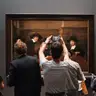 Visitantes de espaldas ante un cuadro de regentes del Siglo de Oro neerlandés en una sala del Rijksmuseum de Ámsterdam