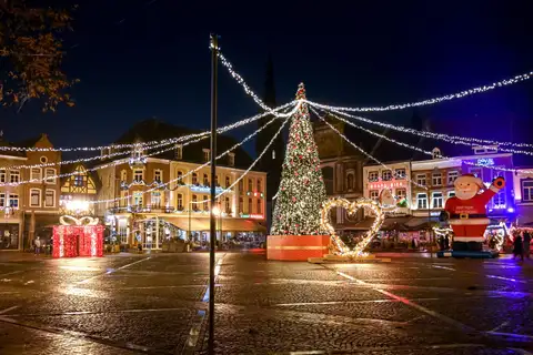 Plaza de Sittard de noche con un gran árbol de Navidad, guirnaldas de luces y casas históricas iluminadas