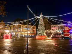 Plaza de Sittard de noche con un gran árbol de Navidad, guirnaldas de luces y casas históricas iluminadas
