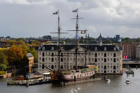 Réplica del velero Amsterdam de la Compañía de las Indias Orientales amarrada frente al edificio del Museo Marítimo de Ámsterdam