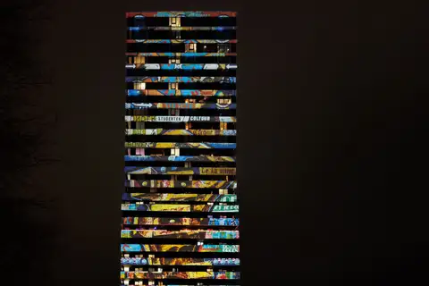 Proyección de imágenes de colores sobre la fachada de una torre a oscuras durante un festival de luz en Eindhoven