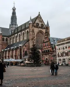 Fachada gótica de ladrillo de la iglesia de San Bavón en la Grote Markt de Haarlem, con peatones en la plaza adoquinada