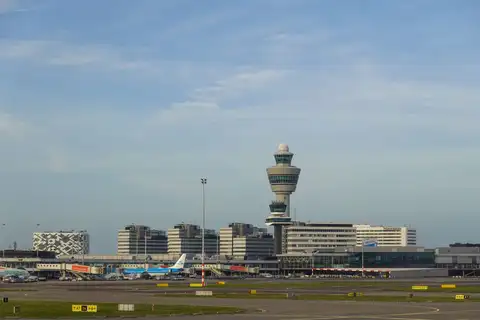 Torre de control y terminales del aeropuerto de Ámsterdam-Schiphol vistos desde la pista, con aviones junto a las pasarelas
