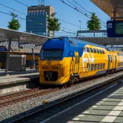 Tren NS de dos pisos, amarillo y azul, detenido en el andén 20b de Utrecht Centraal, con pantalla de salidas y torre al fondo